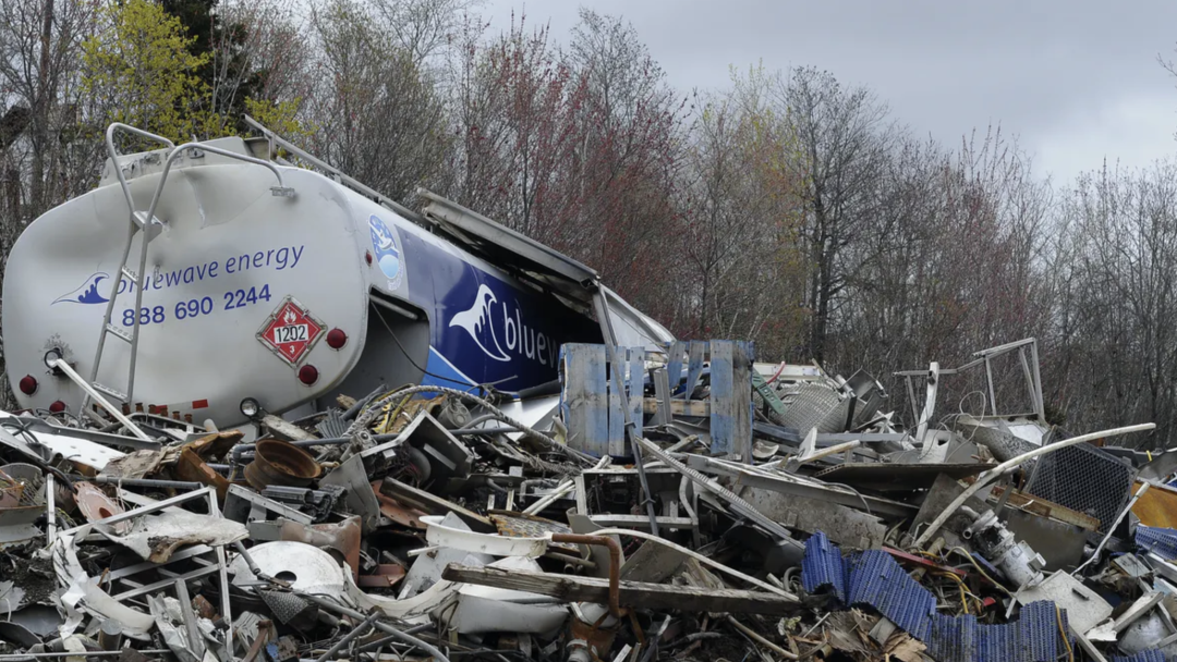 A large pile of Environmentally dangerous dumped metals and mixed refuse including a smashed tanker truck.