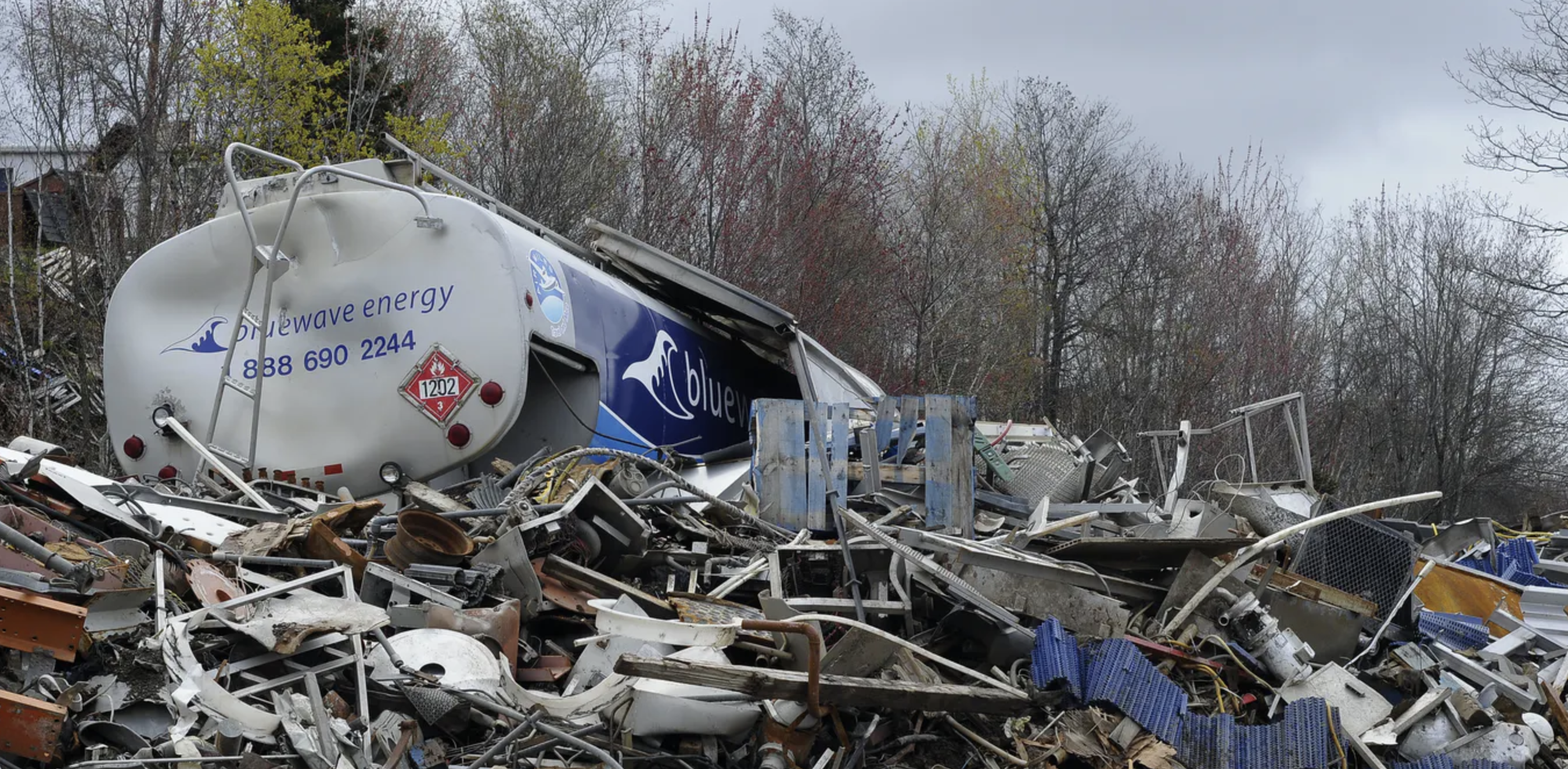 A large pile of Environmentally dangerous dumped metals and mixed refuse including a smashed tanker truck.