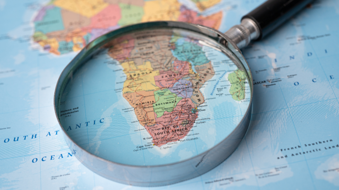 a magnifying glass rests on a close-up of the African continent.